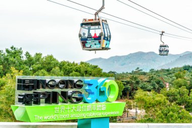 Hong Kong - January 26, 2016: Ngong Ping 360 Skyrail on Lantau Island in Hong Kong is the worlds most amazing cable car experience. Big sign on cableway lift background. clipart