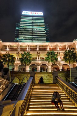 Hong Kong - 18 Ocak 2016: Aydınlanmış Hullet 'in eski Deniz Kuvvetleri Karargahı' nın merdivenlerinde oturan iki genç kadın kameraya poz verdi