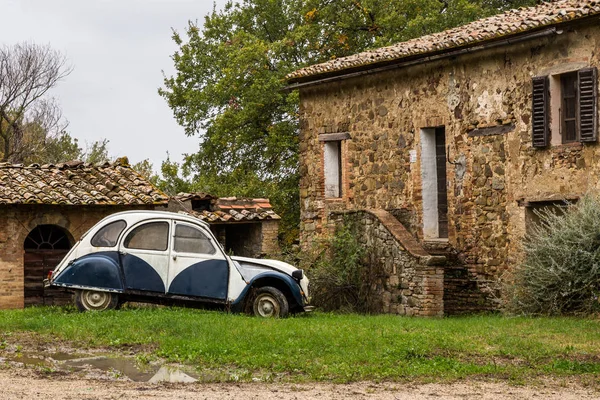 Yağmurdan sonra sonbahar günü üzerinde klasik İtalyan köy evinin eski araba duruyor