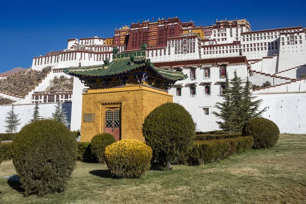 Yeşil bir çatı ve dekoratif bir çalı Lhasa Potala Sarayı önünde küçük bir sarı köşk