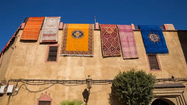 Çok renkli Halılar, sabah güneş tarafından aydınlatılmış evin çatısından asmak