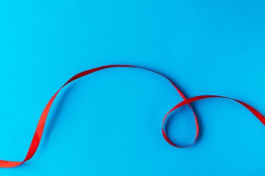 Mavi arka planda kırmızı kurdele. Tatil kartı için iyi bir fikir ya da mesaj için arka plan, mesela bir bilgisayar duvar kağıdı ya da telefonunuzdaki bir ekran koruyucu.