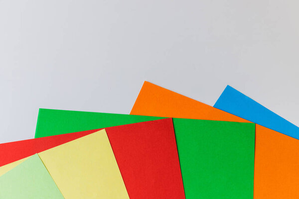 Pattern of multi-colored paper laid out in the form of rays one after another on a white background