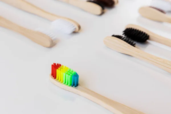 骄傲的概念 彩虹和另一个五彩斑斓的竹子牙刷 口腔卫生天然有机产品 牙齿零浪费 没有塑料概念 地球是安全的 — 图库照片