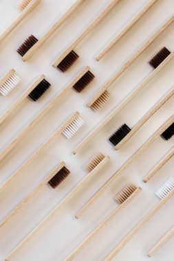 Beyaz arka planda bir grup eko bambu diş fırçası. Farklı renkte. Üst görünüm, boşluğu kopyala. Ağız temizliği için doğal organik ürün. Dişçi sıfır atık ve plastik konsept yok. Dünya için güvenli..