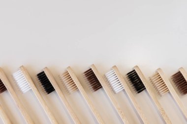 Beyaz arka planda bir grup eko bambu diş fırçası. Farklı renkte. Üst görünüm, boşluğu kopyala. Ağız temizliği için doğal organik ürün. Dişçi sıfır atık ve plastik konsept yok. Dünya için güvenli.. 