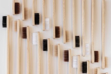 Beyaz arka planda bir grup eko bambu diş fırçası. Farklı renkte. Üst manzara, desen, duvar kağıdı. Ağız temizliği için doğal organik ürün. Dişçi sıfır atık ve plastik konsept yok. Güvenli dünya..