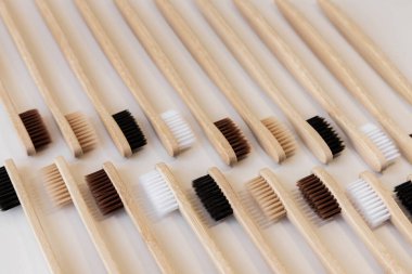 Beyaz arka planda bir grup eko bambu diş fırçası. Farklı renkte. Üst manzara, desen, duvar kağıdı. Ağız temizliği için doğal organik ürün. Dişçi sıfır atık ve plastik konsept yok. Güvenli dünya..