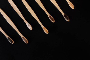 Siyah arka planda bir grup eko bambu diş fırçası. Farklı renkte. Üst görünüm, boşluğu kopyala. Ağız temizliği için doğal organik ürün. Dişçi sıfır atık ve plastik konsept yok. Dünya için güvenli.. 