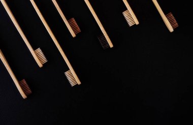 Siyah arka planda bir grup eko bambu diş fırçası. Farklı renkte. Üst görünüm, boşluğu kopyala. Ağız temizliği için doğal organik ürün. Dişçi sıfır atık ve plastik konsept yok. Dünya için güvenli.. 