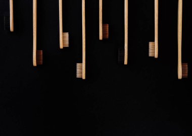 Siyah arka planda bir grup eko bambu diş fırçası. Farklı renkte. Üst görünüm, boşluğu kopyala. Ağız temizliği için doğal organik ürün. Dişçi sıfır atık ve plastik konsept yok. Dünya için güvenli.. 