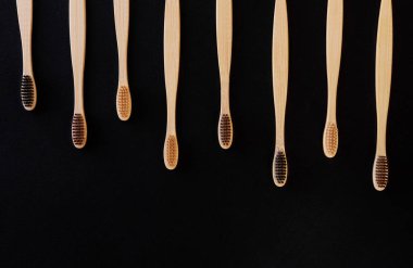 Siyah arka planda bir grup eko bambu diş fırçası. Farklı renkte. Üst görünüm, boşluğu kopyala. Ağız temizliği için doğal organik ürün. Dişçi sıfır atık ve plastik konsept yok. Dünya için güvenli.. 