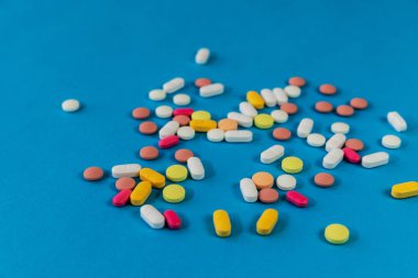Farklı ilaç hapları, mavi arka planda haplar. Mesaj için yeri olan bir sürü hap ve tablet. Sağlık hizmetleri. Üst Manzara. Uzayı kopyala Yeni imaj. Farmasötik resim. - Yakın çekim. Yakın plan. Yumuşak odak