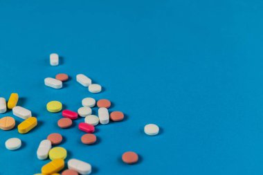 Farklı ilaç hapları, mavi arka planda haplar. Mesaj için yeri olan bir sürü hap ve tablet. Sağlık hizmetleri. Üst Manzara. Uzayı kopyala Yeni imaj. Farmasötik resim. - Yakın çekim. Yakın plan. Yumuşak odak