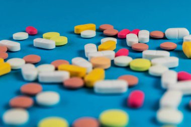 Farklı ilaç hapları, mavi arka planda haplar. Bir sürü ilaç hapı ve metinler için bir sürü tablet. Sağlık hizmetleri. Üst Manzara. Uzayı kopyala Yeni imaj. Eczacılık hapları. - Yakın çekim. Yumuşak odak. 