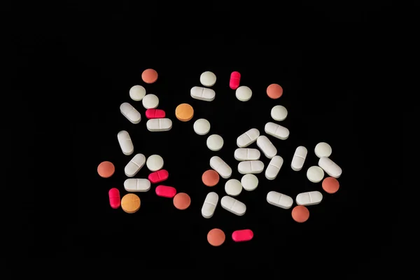 Different medicine pills, tablets on black background. Many pills and tablets with space for text. Health care. Top view. Copy space. New image. Pharmaceutical picture. Nice flatlay.