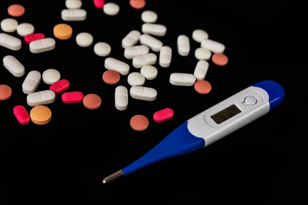 Farklı Ilaç Hapları Tabletler Siyah Arka Planda Termometre Bir Sürü — Stok fotoğraf