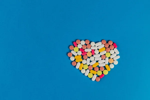 Muitas Pílulas Comprimidos Diferentes Dobrados Forma Coração Fundo Azul Muitas — Fotografia de Stock