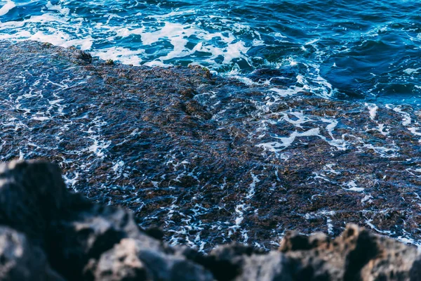 地中海的一片 有泡沫和深蓝色的石头 前景是模糊的石头 不错的海景 — 图库照片