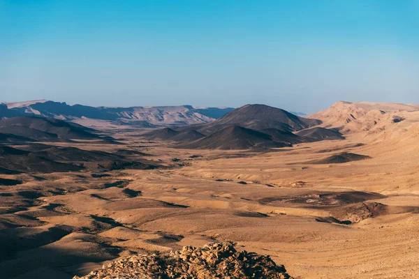 Makhtesh ramon crater landscape in Israel\'s Negev Desert. Near to Mizpe Ramon city on south Israel. Sand dunes in gold and black. Beautiful blue sky in the desert. Places for hiking in Israel