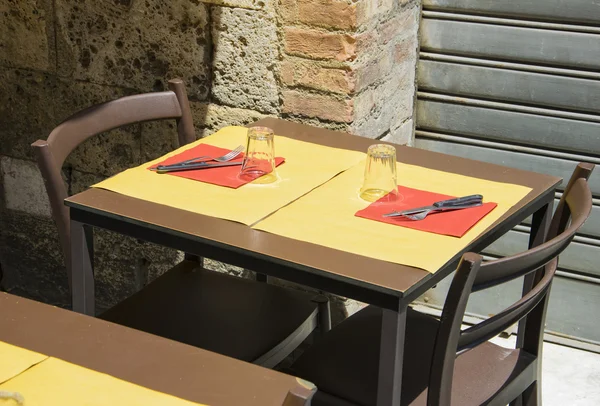 Sillas de restaurante vacías y mesa en la antigua calle italiana — Foto de Stock