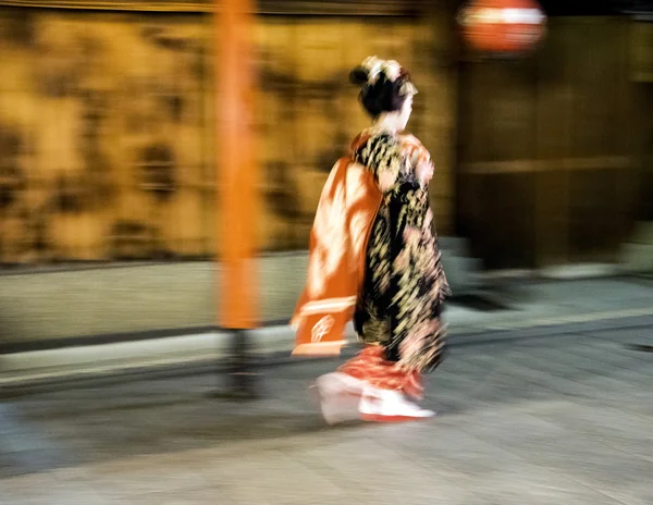 Geisha apanesa caminata rápida durante la noche lluviosa en el distrito de Gion en Kyotom Japón — Foto de Stock