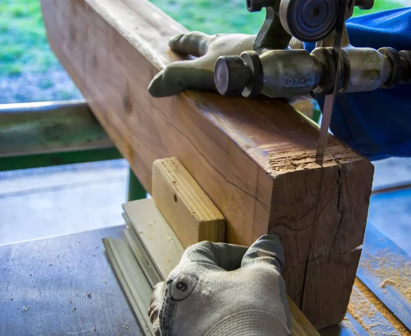 Carpenter workplace. Man using saw to cut wood — Stock Photo, Image