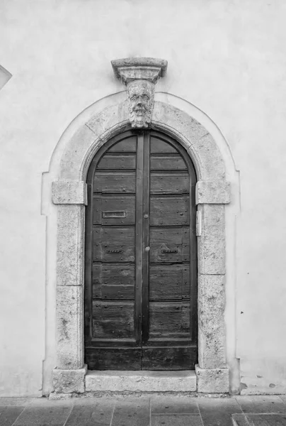 A porta de madeira da entrada em uma casa italiana velha . — Fotografia de Stock