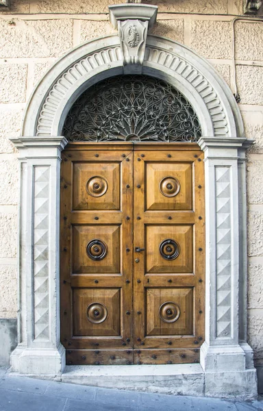 La puerta de entrada de madera en una antigua casa italiana . — Foto de Stock