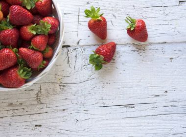 Kase çilek Beyaz ahşap rustik arka planda Üstten Görünüm.