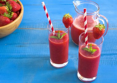 Ev yapımı çilekli güler yüzlü lezzetli rustik mavi ahşap arka plan üzerinde.