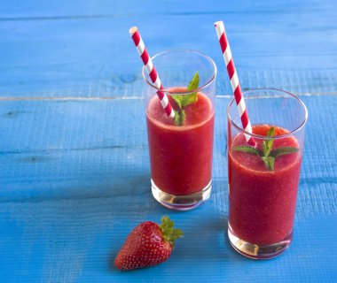 Ev yapımı çilekli güler yüzlü lezzetli rustik mavi ahşap arka plan üzerinde