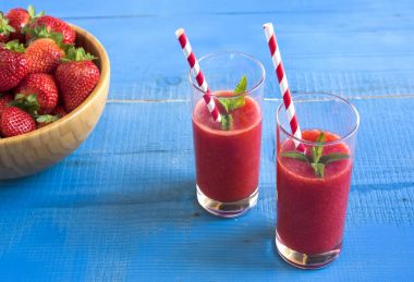 Ev yapımı çilekli güler yüzlü lezzetli rustik mavi ahşap arka plan üzerinde