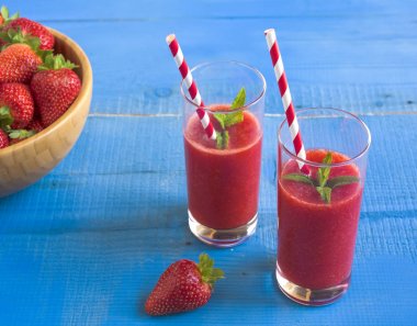 Ev yapımı çilekli güler yüzlü lezzetli rustik mavi ahşap arka plan üzerinde