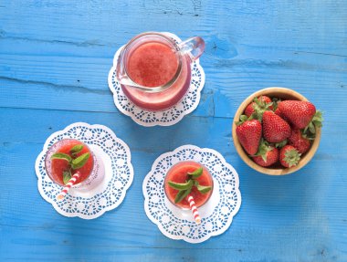  Ev yapımı çilekli güler yüzlü lezzetli rustik mavi ahşap arka plan üzerinde