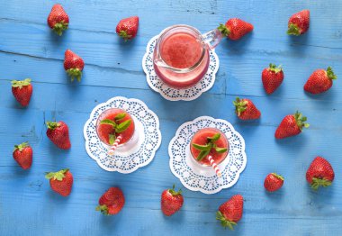  Ev yapımı çilekli güler yüzlü lezzetli rustik mavi ahşap arka plan üzerinde