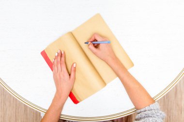 İnsan eli kalem defter ahşap masa arka plan üzerinde yazma ile