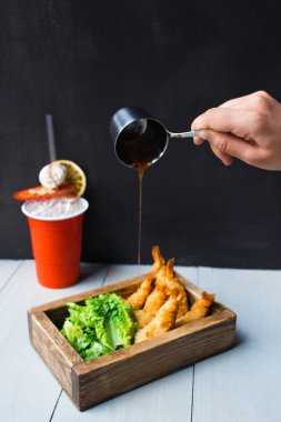 Fried organik karides kokteyl sos ve içki kokteyl ve kaktüs bir ahşap masa ve siyah arka plan ile