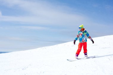 Bir güneşli sabah yamaçlarında üzerinde kadın snowboard