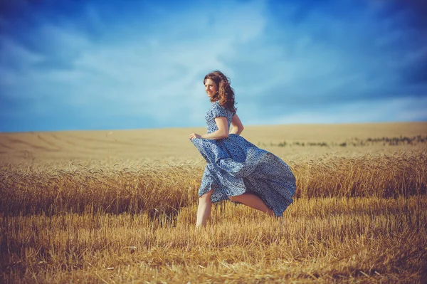 Chica corriendo en un campo de trigo — Foto de Stock