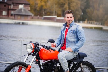 trendy adam telefonda konuşurken bir motosiklet üzerinde