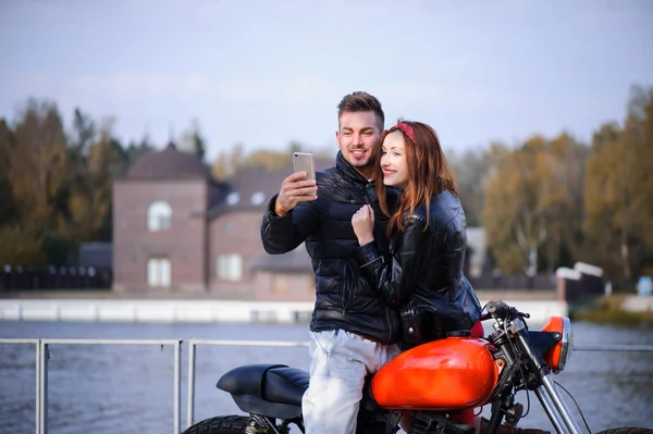 Cara na moto com a menina fazendo uma selfie — Fotografia de Stock