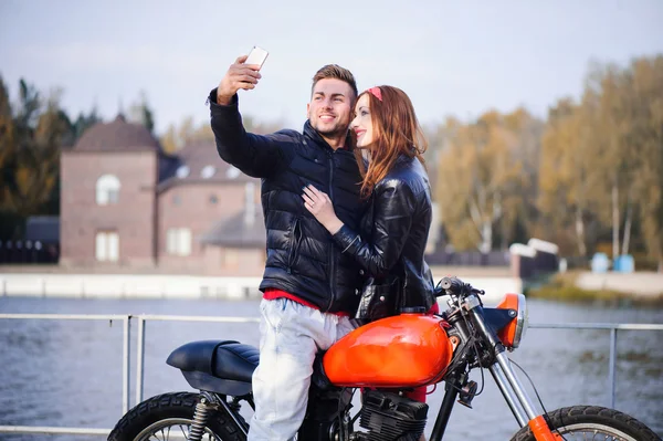 Cara na moto com a menina fazendo uma selfie — Fotografia de Stock