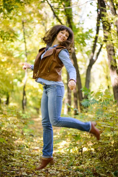Happy woman in red jacket in the woods — Stock Photo, Image