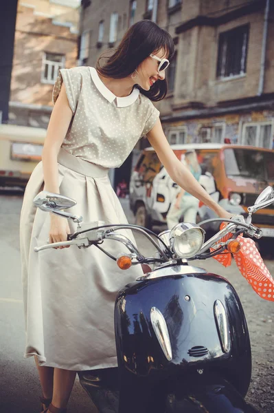 Sonrisa mujer hermosa y de moda en un scooter — Foto de Stock