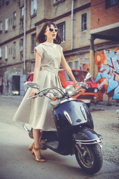 Mujer hermosa y de moda en un scooter — Foto de Stock