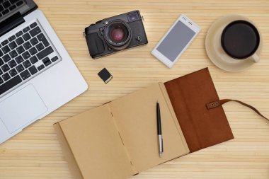 Vintage hipster ahşap üst Danışma, belgili tanımlık laptop ve bir fincan kahve, bir kamera, bir deri defter, bir telefon