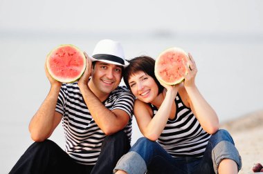 couple sitting on beach with watermelon clipart