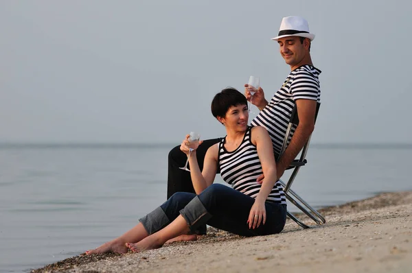 Casal sentado na praia com vinho — Fotografia de Stock