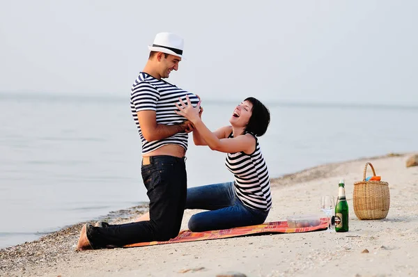 Pareja sentada en la playa con sandía — Foto de Stock